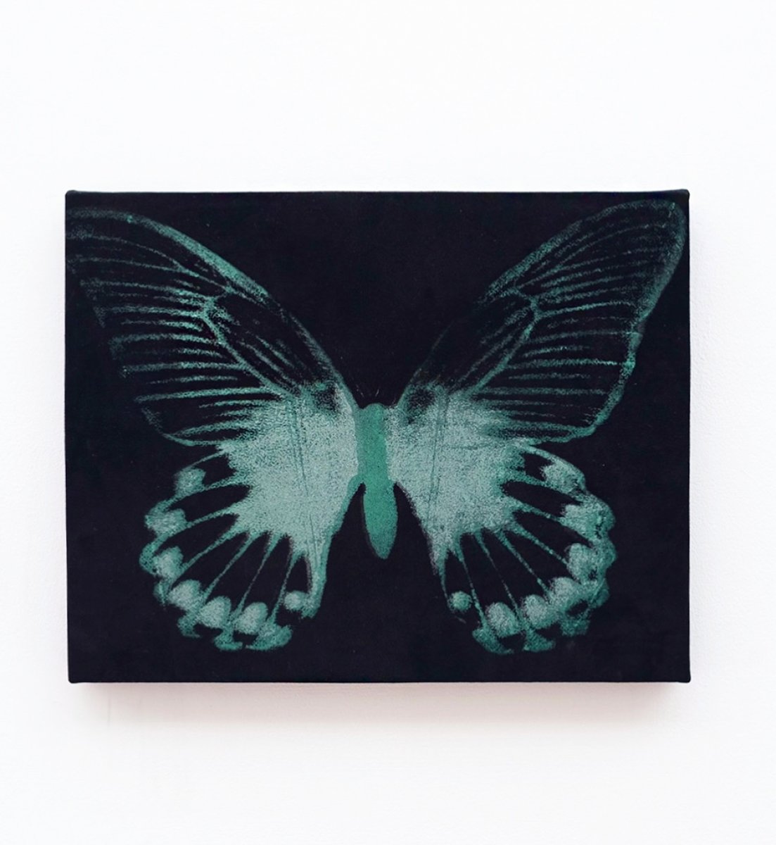 Silkscreen of green metallic butterfly on black suede.