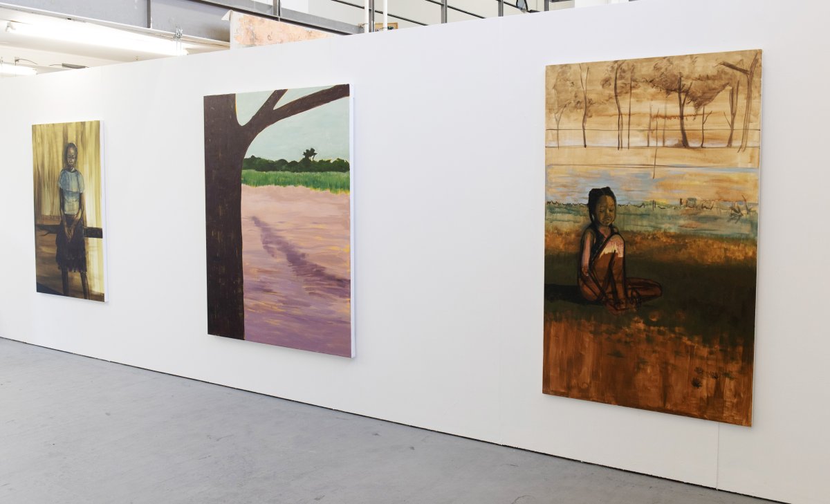 Installation photo of three paintings. The first of a girl sitting on the ground outside; the second of a landscape; the third, a girl sitting on a bench