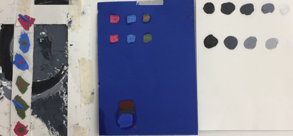 Photo of colour exercise, painted squares of colour agains a blue background and black splotches on white paper, from Colour in Practice course